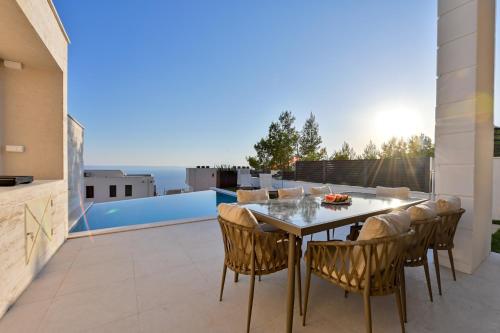 a patio with a table and chairs on a balcony at Villa Rosemary West in Makarska