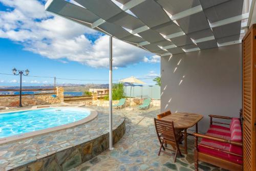a patio with a pool and a table and chairs at Neria Villas Collection in Áptera