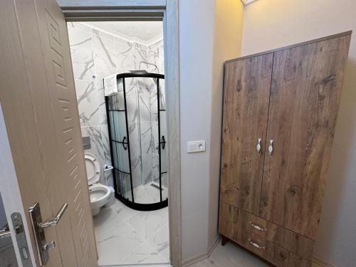 baño con aseo y puerta de madera en pilot hotel en Arnavutköy