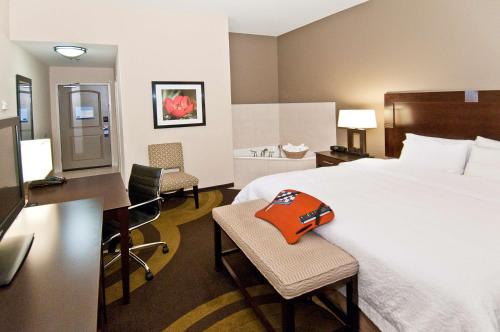 a hotel room with a bed and a desk and chairs at Hampton Inn Maumelle in Maumelle