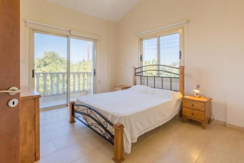 1 dormitorio con cama y ventana grande en Rose Villas Collection, en Kato Yialia