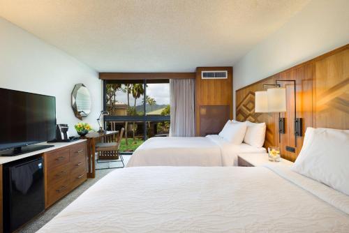 a hotel room with two beds and a flat screen tv at Hilton Garden Inn Kauai Wailua Bay, HI in Kapaa