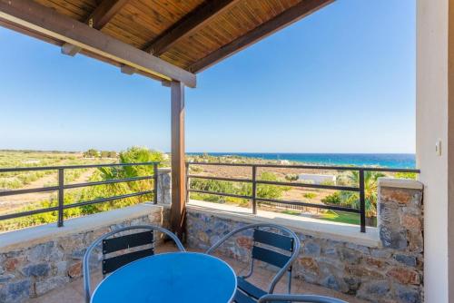 a table and chairs on a balcony with a view of the ocean at Spiros Villas Collection in Sfakiá
