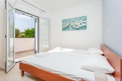 een slaapkamer met een bed en een glazen schuifdeur bij Villa Europe Ena in Lakíthra