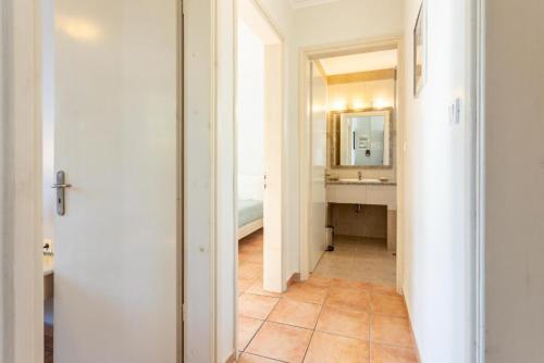 a hallway with a bathroom with a sink and a mirror at Maria Beach House in Dhamoulianáta