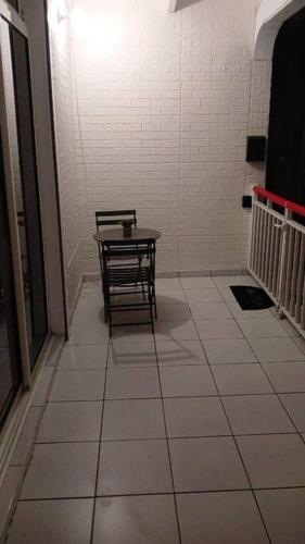 a room with a table and a bench in a hallway at Jolie petite maison tout équipée in Le Gosier