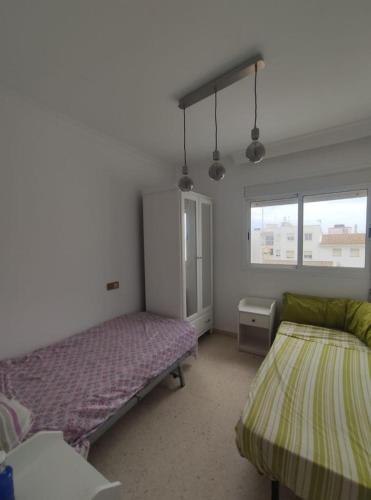a bedroom with two beds and a window at Ático en Barbate in Barbate