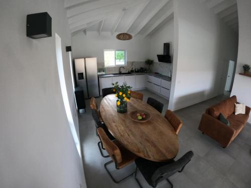 cocina y comedor con mesa de madera y sillas en Villa Nisa - HOMEofEase - Villapark Fontein, en Fontein