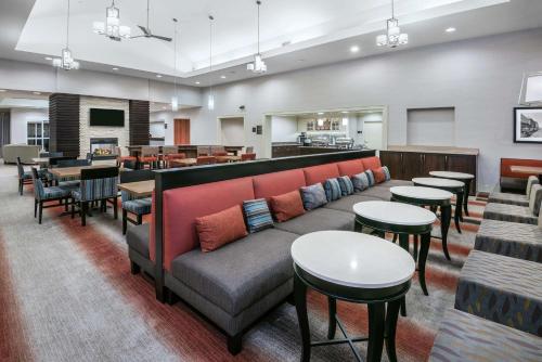 a waiting room with a couch and tables and chairs at Homewood Suites Laredo at Mall Del Norte in Laredo