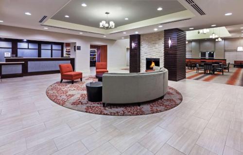 a lobby with a fireplace and chairs and tables at Homewood Suites Laredo at Mall Del Norte in Laredo