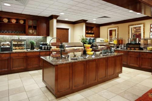 a large kitchen with wooden cabinets and a counter at Homewood Suites Laredo at Mall Del Norte in Laredo