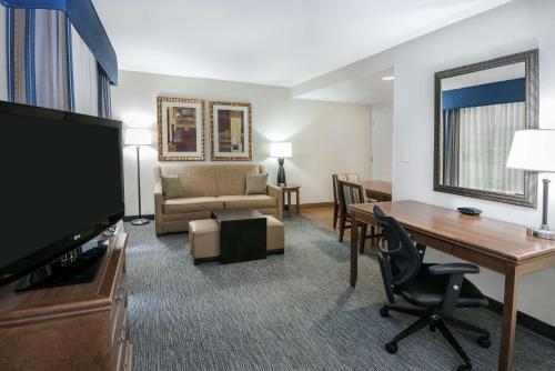 a hotel room with a desk and a living room at Homewood Suites Laredo at Mall Del Norte in Laredo
