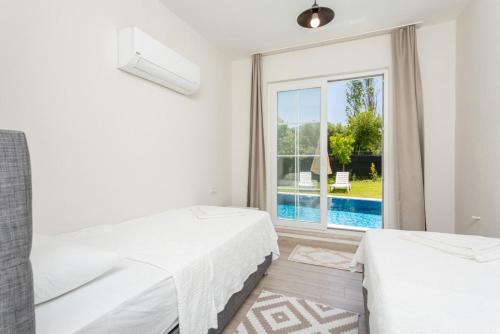 a white bedroom with a view of the pool at Villa Zonkdemir in Dalyan