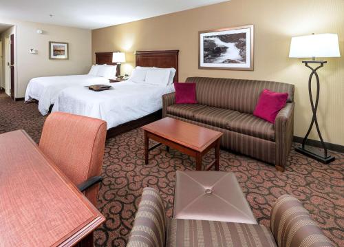 a hotel room with a bed and a couch at Hampton Inn Littleton in Littleton