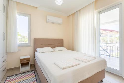 a bedroom with a bed and a large window at Villa Veli in Dalyan
