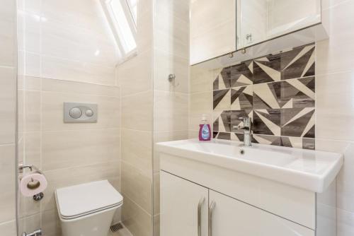 a white bathroom with a sink and a toilet at Villa Veli in Dalyan