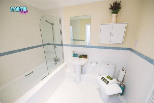 a bathroom with a shower toilet and a sink at Spacious Central Leatherhead Apt Long Term Stay in Leatherhead