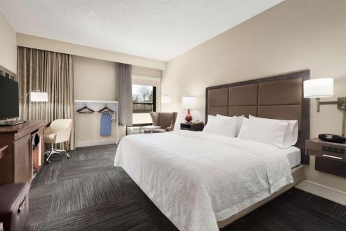 a hotel room with a large bed and a television at Hampton Inn Lawrence in Lawrence