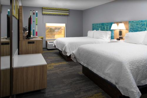 ein Hotelzimmer mit 2 Betten und einem Flachbild-TV in der Unterkunft Hampton Inn Gretna - Smith Mountain Lake in Gretna