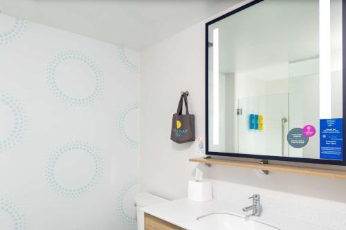 a bathroom with a mirror and a sink at Tru By Hilton Lynchburg, Va in Lynchburg