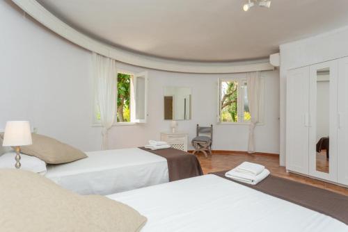 a bedroom with two beds and two windows at Villa La Torre in Alcudia