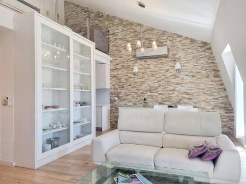- un salon avec un canapé blanc et un mur en briques dans l'établissement Aurore Duplex - New Apartment, à Lisbonne