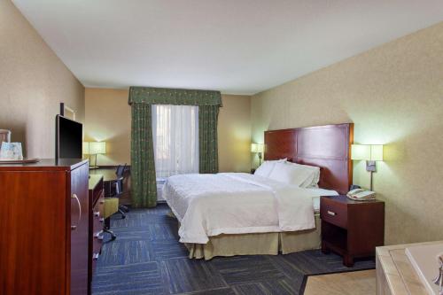 um quarto de hotel com uma cama e uma televisão em Hampton Inn and Suites Merced em Merced