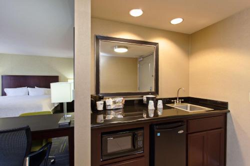 Habitación de hotel con lavabo y cama en Hampton Inn and Suites Merced, en Merced