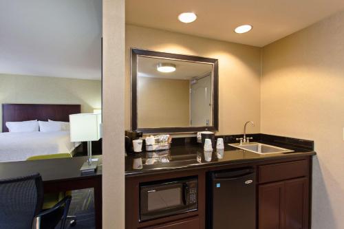 a hotel room with a sink and a bed at Hampton Inn and Suites Merced in Merced