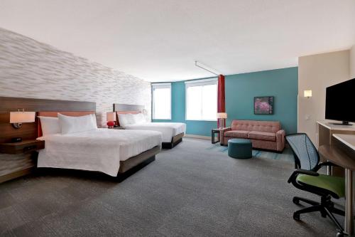 um quarto de hotel com duas camas e uma televisão de ecrã plano em Home2 Suites By Hilton Turlock, Ca em Turlock