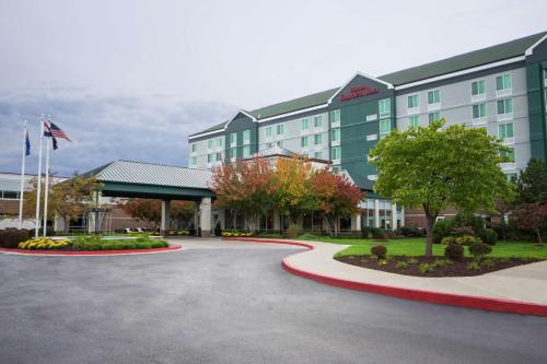 a hotel building with a flag in front of it at Hilton Garden Inn Independence in Independence