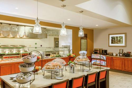 a large kitchen with a table with several plates of food at Hilton Garden Inn Independence in Independence