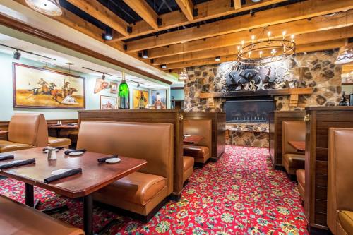 a restaurant with tables and chairs and a fireplace at Hilton Garden Inn Independence in Independence