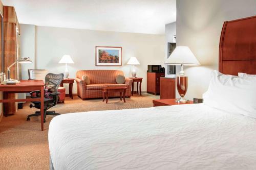 a hotel room with a bed and a desk and chair at Hilton Garden Inn Independence in Independence