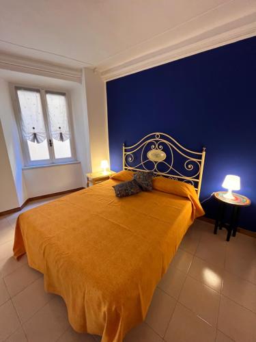 a bedroom with a large bed with a blue wall at Casa Gambusso historical house magnificent Lake View in Verbania
