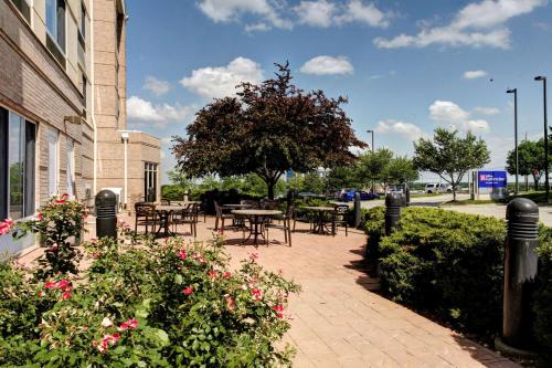 patio ze stołami i kwiatami obok budynku w obiekcie Hilton Garden Inn Overland Park w mieście Overland Park