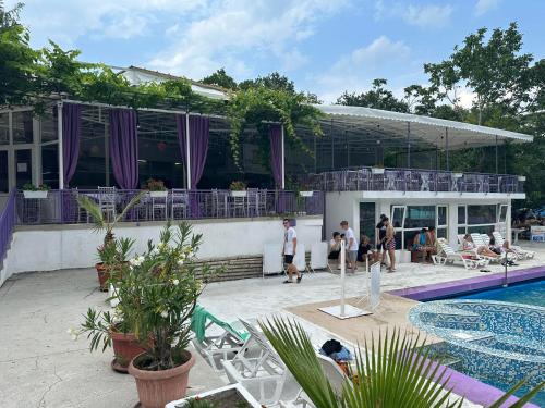 a group of people standing around a swimming pool at Парк-хотел РИВА in Golden Sands