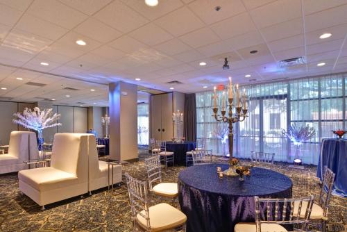 a conference room with tables and chairs and a chandelier at Embassy Suites by Hilton Orlando Downtown in Orlando