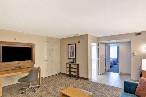 a living room with a television and a couch at Embassy Suites by Hilton Orlando Downtown in Orlando