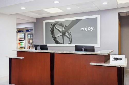 an office reception counter with a presentation on the wall at Hampton Inn & Suites Orlando International Drive North in Orlando