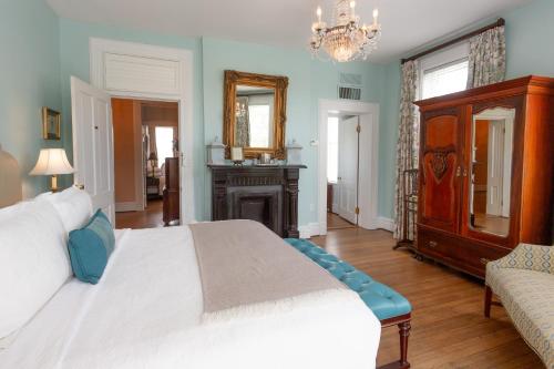 a bedroom with a large bed and a chandelier at Kehoe House, Historic Inns of Savannah Collection in Savannah