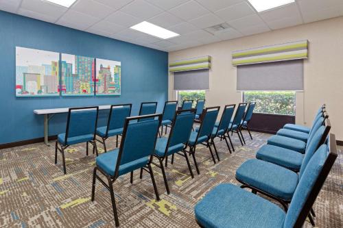 a waiting room with blue chairs and a table at Hampton Inn & Suites Orlando International Drive North in Orlando