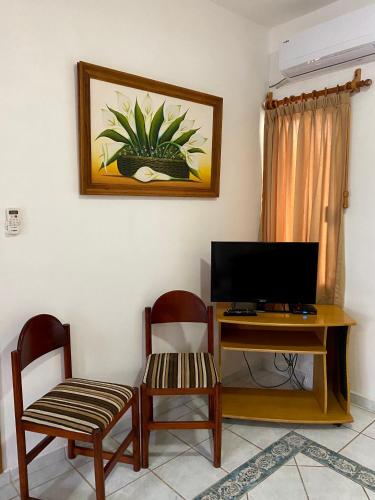 a living room with a desk with a tv and two chairs at Quinta Sea in Playa del Carmen