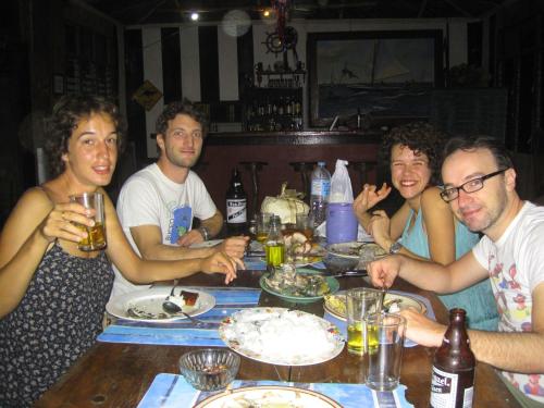 a group of people sitting around a table eating food at Paseo Del Mar Seaside Inn in Jagna