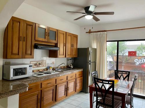 a kitchen with wooden cabinets and a table with chairs at Quinta Sea in Playa del Carmen
