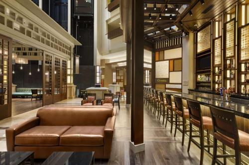 a lobby with leather couches and a bar at Embassy Suites by Hilton Orlando Lake Buena Vista South in Kissimmee