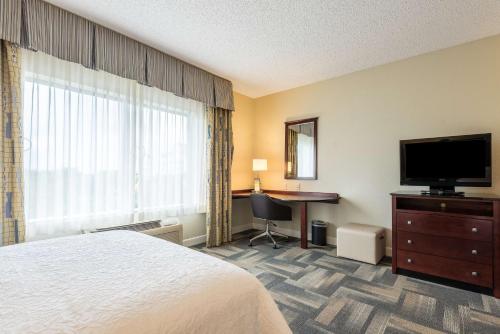 a hotel room with a bed and a flat screen tv at Hampton Inn & Suites Orlando-South Lake Buena Vista in Kissimmee