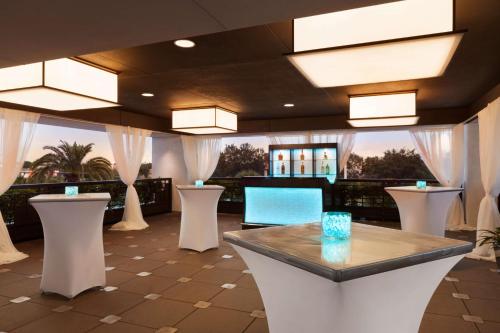 a lobby with a table and white stools at Embassy Suites by Hilton Orlando Lake Buena Vista South in Kissimmee
