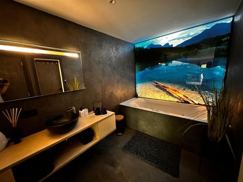 een badkamer met een groot aquarium aan de muur bij Plaisances, les plaisirs du bord de Meuse - Chambre d'hôtes avec baignoire spa in Profondeville