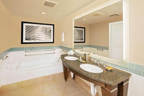 a bathroom with two sinks and a tub at Parc Soleil by Hilton Grand Vacations in Orlando